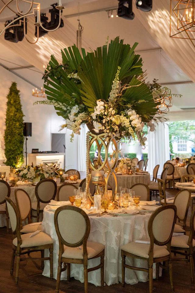 Tented wedding reception with chandeliers and evergreens