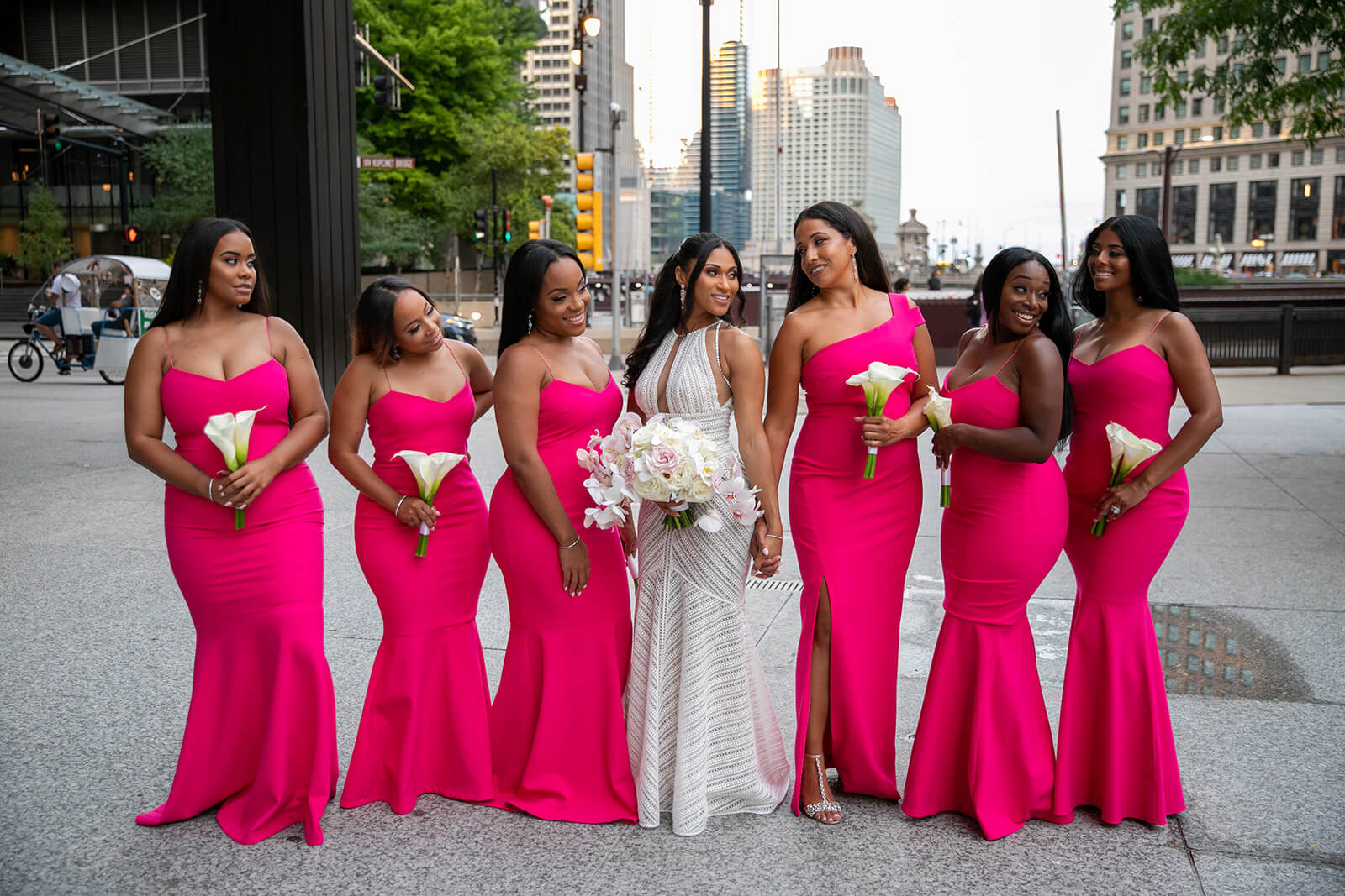Bridesmaids wearing hot pink bridesmaids dresses, posing with bride in the middle of a Chicago street