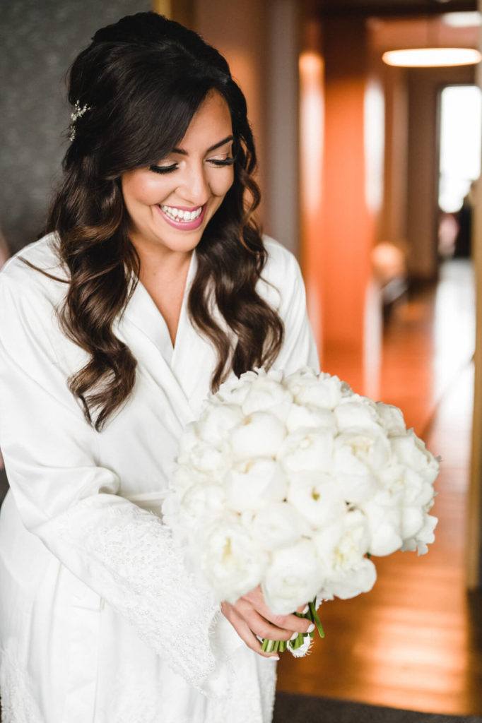 bride smiles at her bridal bouquet to stay calm on wedding day