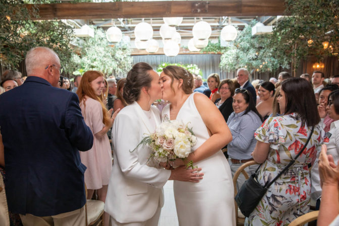 Same-sex chicago wedding, brides kissing after wedding ceremony.