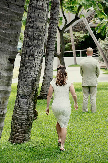 bride walking toward groom for wedding first look at Halekulani hotel in Hawaii