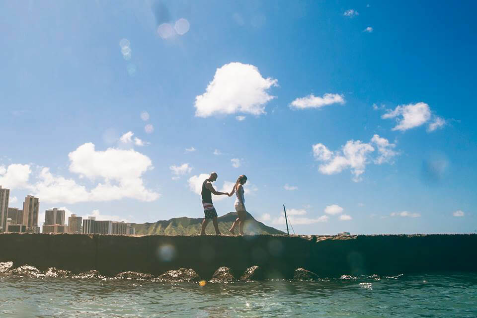 couple walking in Waikiki, Hawaii to take photos in ocean